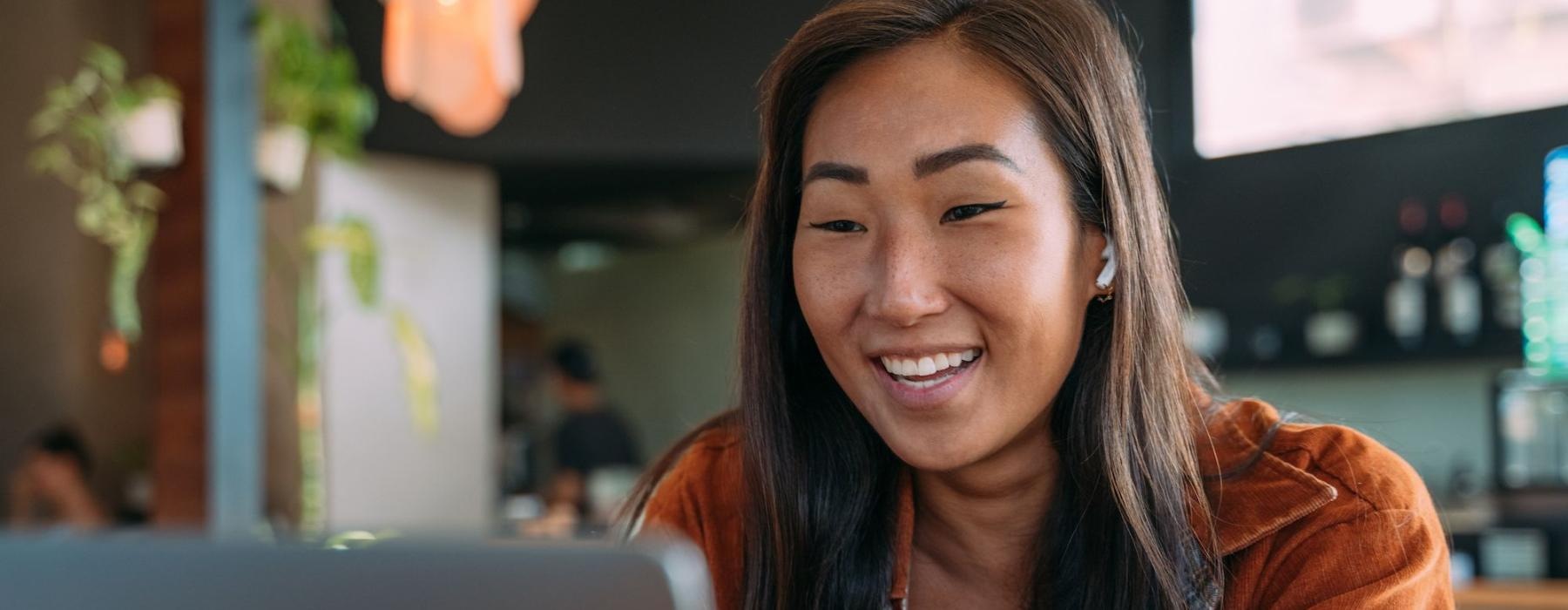 a woman smiling while working on laptop